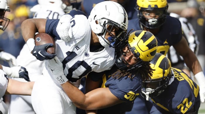 Michigan linebacker Mike Morris tackles Penn State running back Nicholas Singleton in a game.